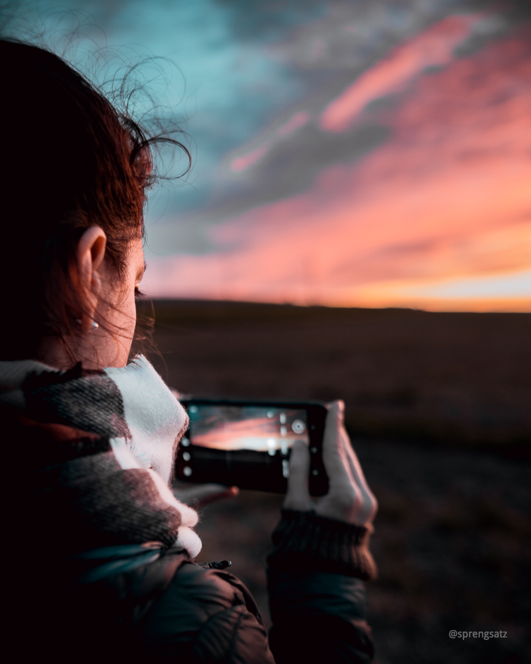 Frau mit Smartphone fotografiert den Sonnenuntergang im Zellertal (Donnersbergkreis)