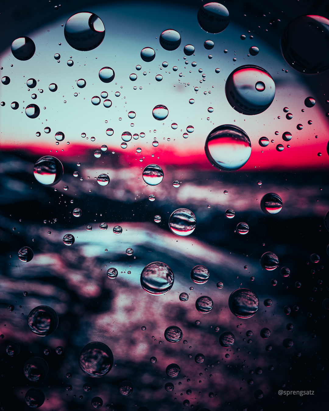 Wassertropfen vor unscharfem Sonnenuntergang