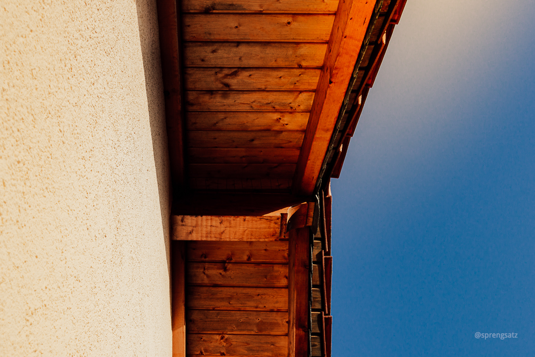 Hausdach im Sonnenschein vor blauem Himmel