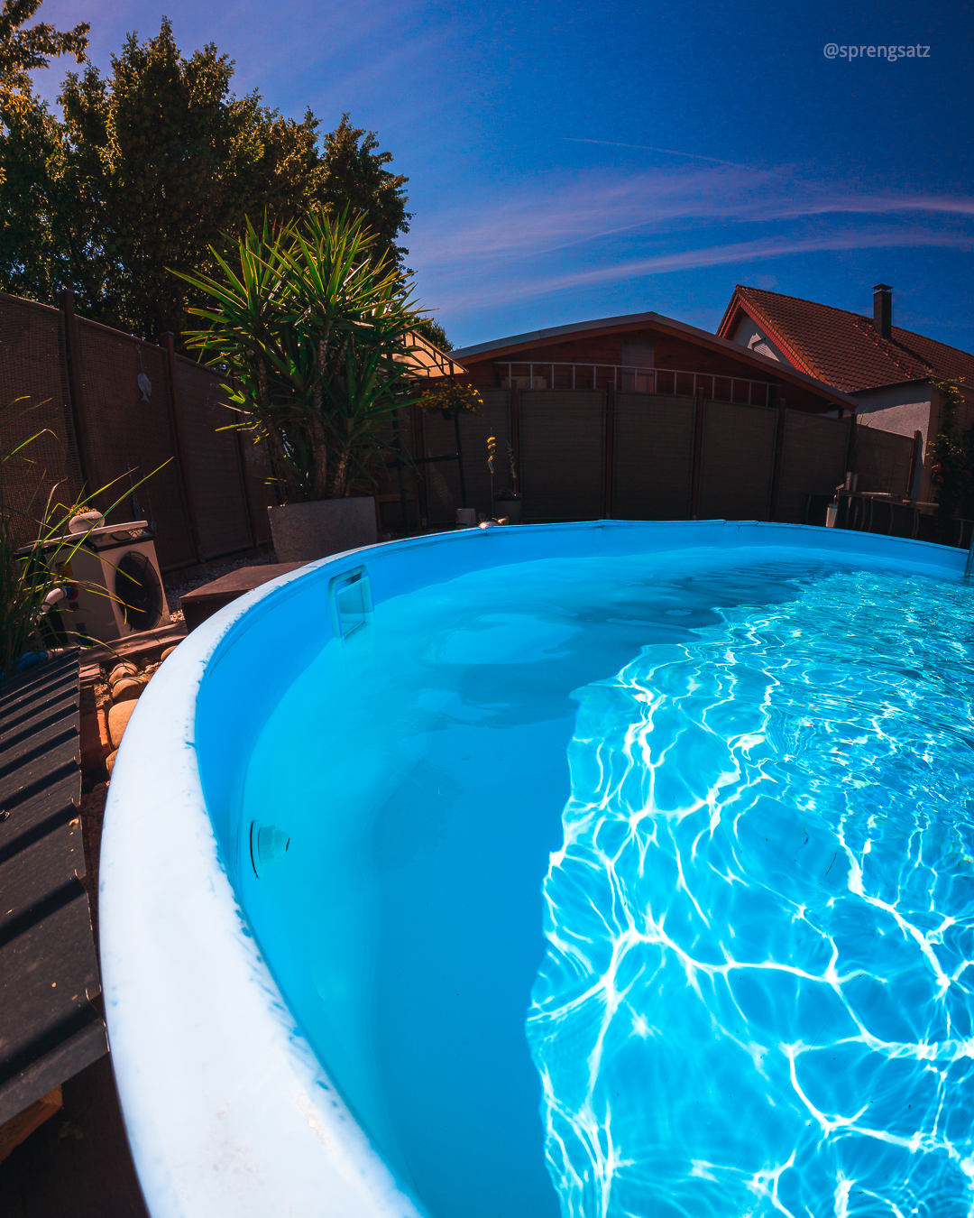 Mit glänzendem Wasser gefüllter Swimmingpool bei Sonnenschein