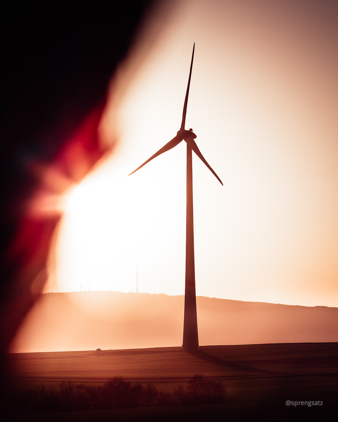 Ein Windrad vor dem Donnersberg im Sonnenlicht bei Sonnenuntergang